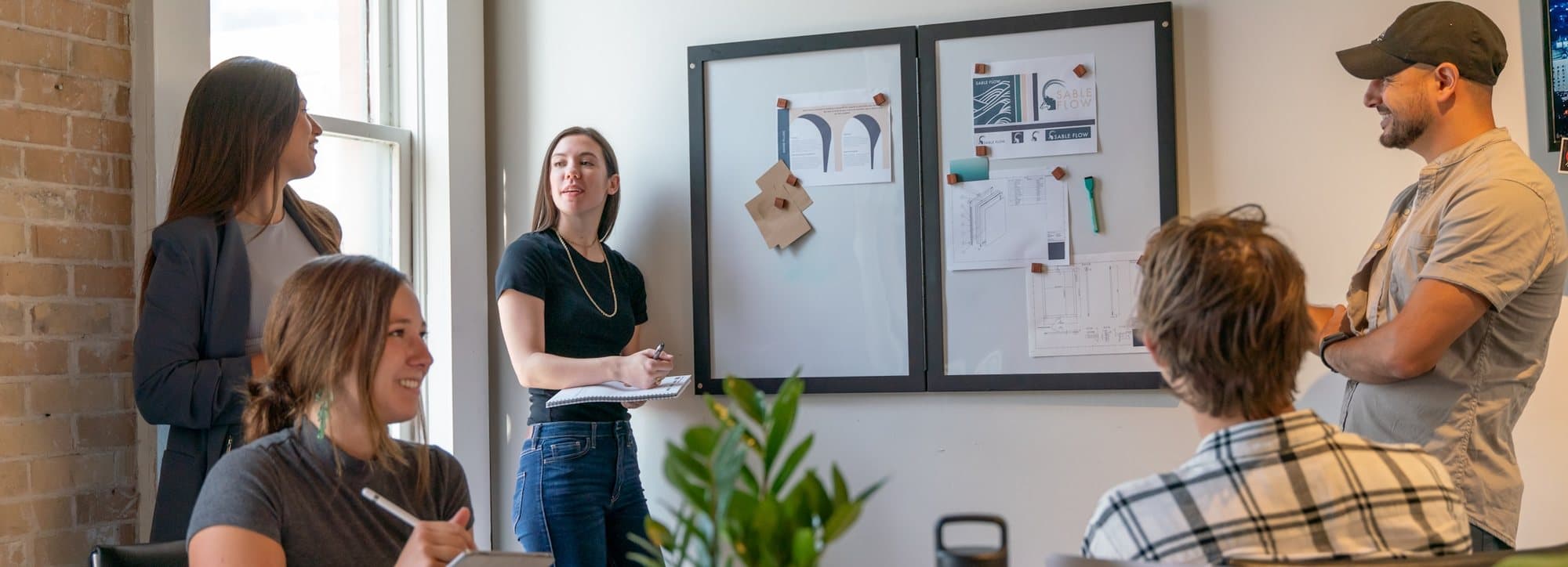 A team reviewing work pinned across a studio wall